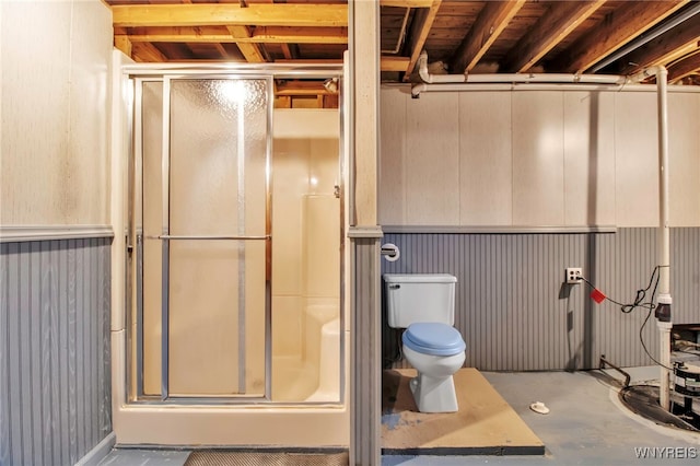 full bath with toilet, concrete flooring, and a stall shower