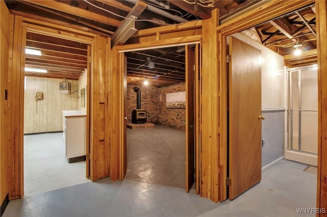 below grade area featuring a wood stove and brick wall