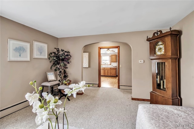 interior space featuring arched walkways, baseboards, carpet, and a baseboard heating unit