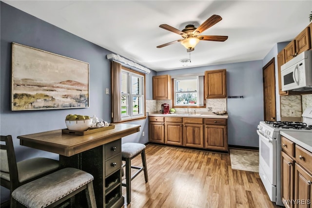 kitchen with brown cabinets, tasteful backsplash, and white appliances