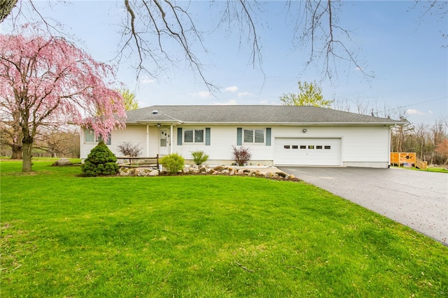 ranch-style home featuring an attached garage, driveway, and a front yard