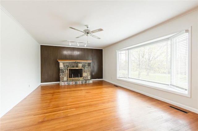 unfurnished living room featuring crown molding, ceiling fan, visible vents, and track lighting