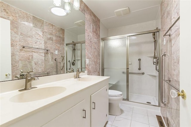 bathroom with a sink, marble finish floor, and a stall shower