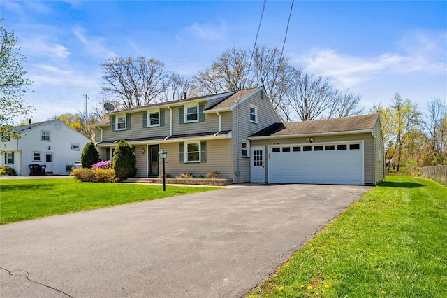 view of front of home with a garage, a front lawn, and driveway