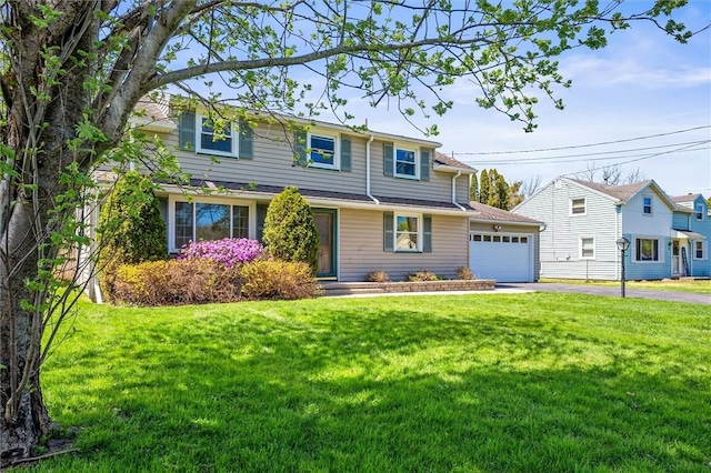 traditional-style house with an attached garage, a front lawn, and aphalt driveway