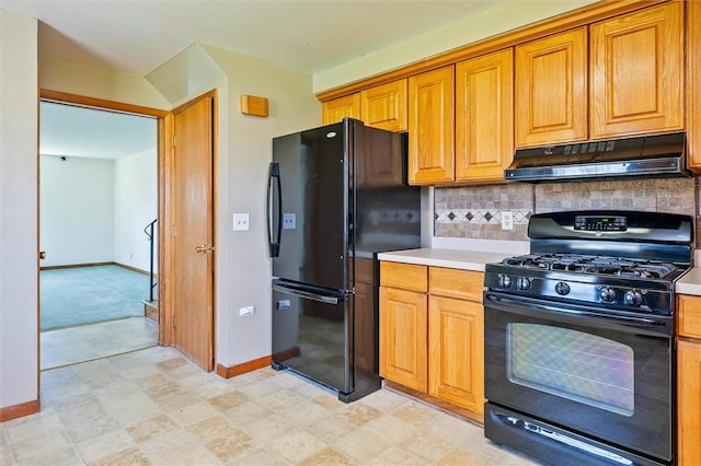 kitchen with under cabinet range hood, baseboards, black appliances, and light countertops