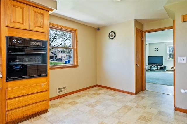 kitchen with visible vents, baseboards, and black oven