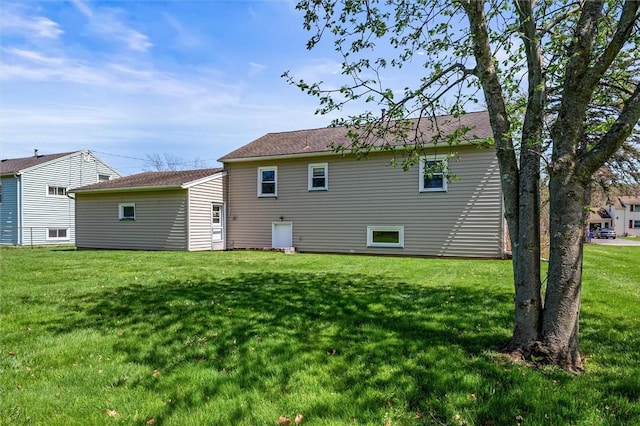 rear view of house featuring a lawn