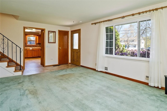 foyer entrance featuring a healthy amount of sunlight, baseboards, and stairs