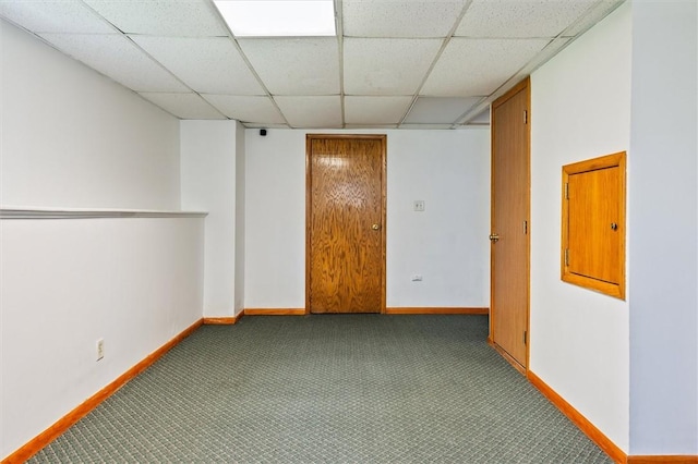 spare room featuring baseboards, a paneled ceiling, and carpet