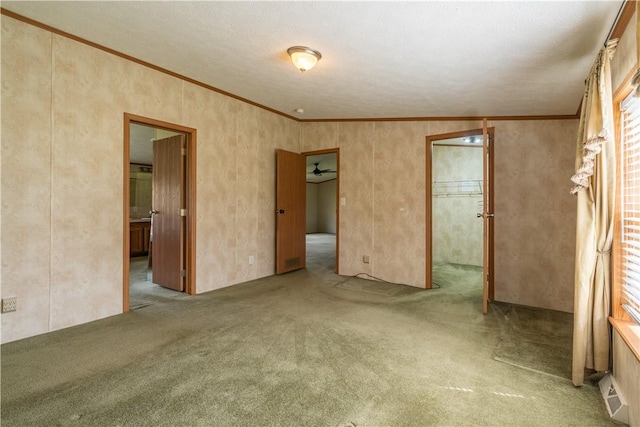 unfurnished bedroom with carpet flooring, ornamental molding, and ensuite bath