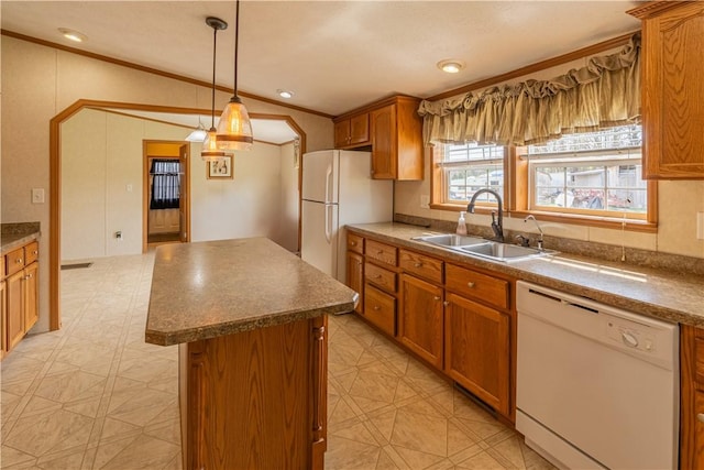 kitchen with a center island, a sink, white appliances, and ornamental molding