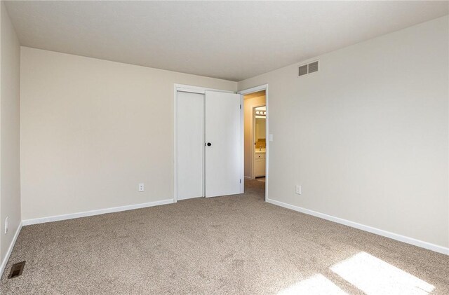 unfurnished room with visible vents, carpet, and baseboards