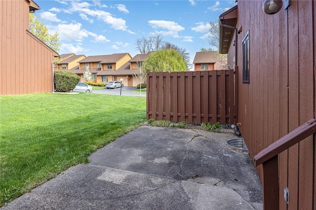 view of yard featuring a patio area, fence, and a residential view