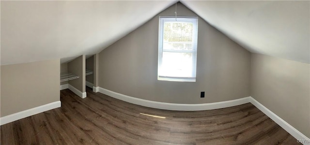 bonus room with baseboards, lofted ceiling, and wood finished floors