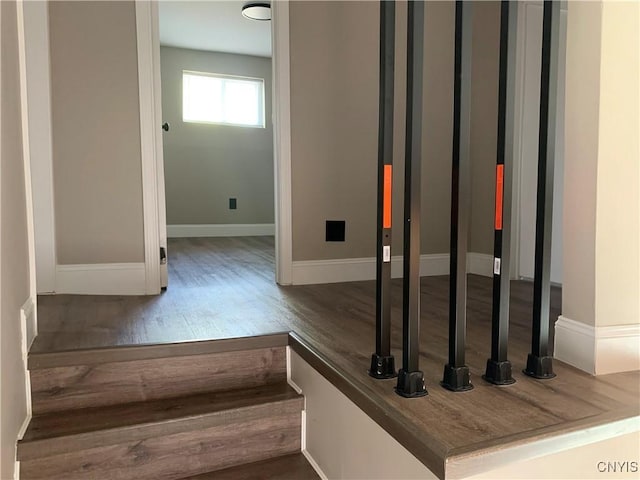 staircase with baseboards and wood finished floors