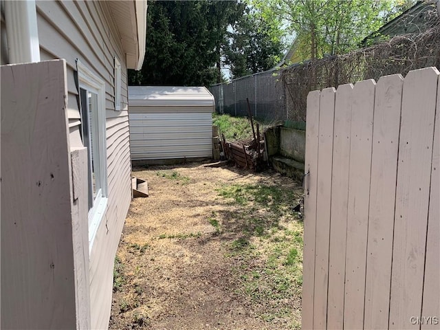 view of yard with a storage unit, an outdoor structure, and fence