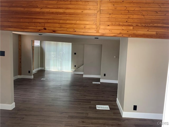 spare room with baseboards, visible vents, and dark wood-type flooring