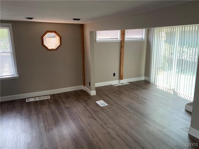 spare room with visible vents, baseboards, and wood finished floors