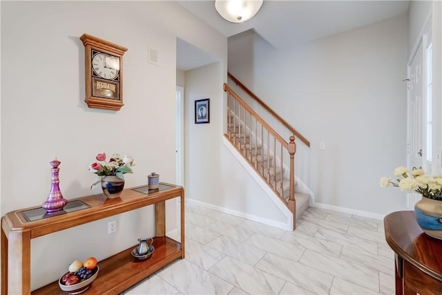 staircase featuring baseboards and marble finish floor