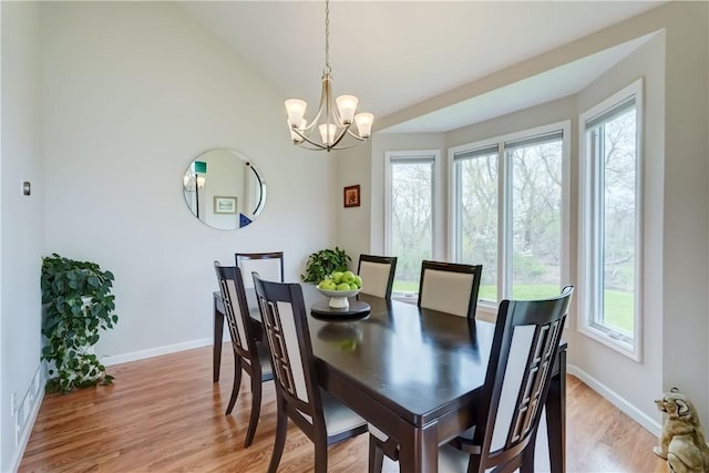dining space featuring an inviting chandelier, light wood-style floors, plenty of natural light, and baseboards