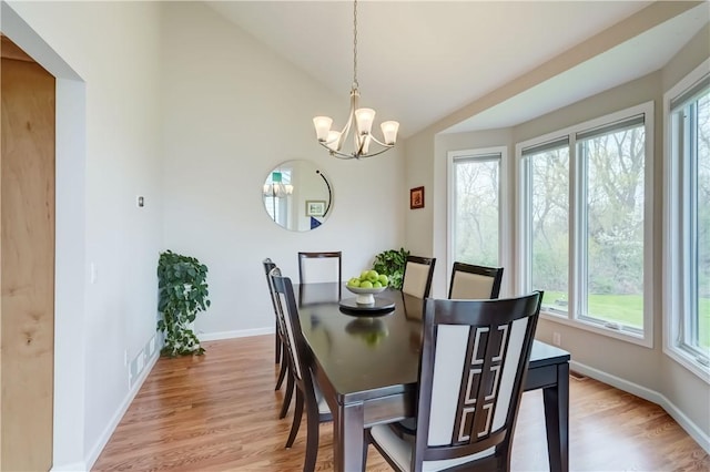 dining space with light wood-style floors, baseboards, and a notable chandelier