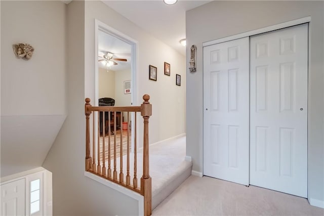 corridor featuring an upstairs landing and carpet