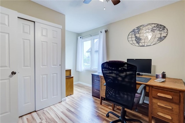 home office featuring baseboards, light wood finished floors, and ceiling fan