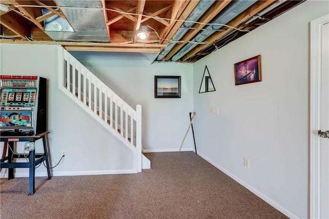basement featuring baseboards, carpet, and stairs