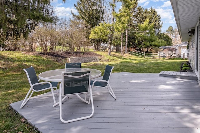 deck with fence, outdoor dining space, and a yard