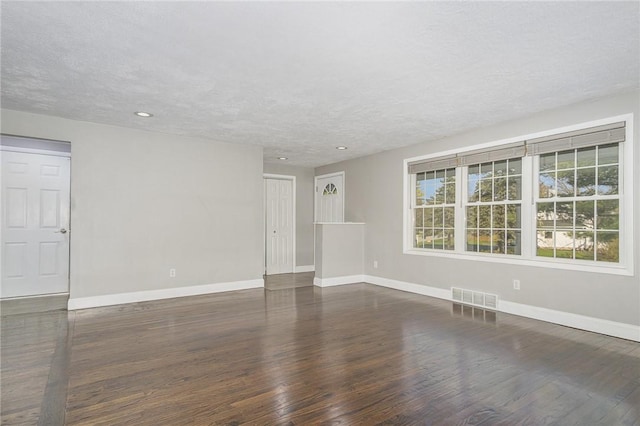 spare room with visible vents, baseboards, and wood finished floors