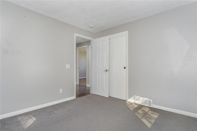 unfurnished bedroom with visible vents, carpet flooring, baseboards, and a closet