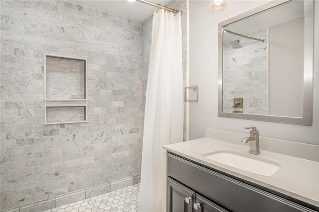 full bath featuring vanity and tiled shower
