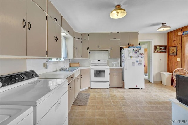 kitchen featuring a sink, light countertops, white appliances, and independent washer and dryer