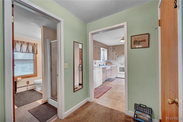 hallway featuring baseboards, a baseboard radiator, light colored carpet, and a wealth of natural light
