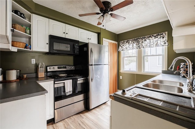 kitchen featuring a ceiling fan, light wood-style floors, white cabinetry, a sink, and appliances with stainless steel finishes
