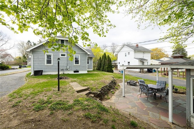 back of property with a fire pit, a gazebo, and a patio area