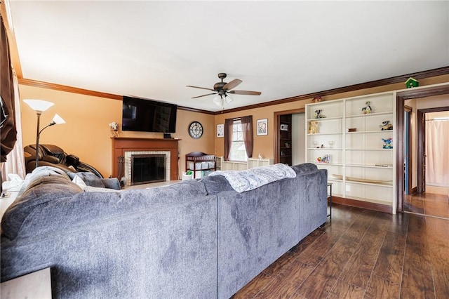 living room with a ceiling fan, dark wood-style flooring, a glass covered fireplace, and ornamental molding