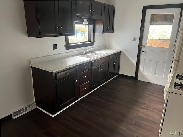 kitchen with visible vents, a sink, dark wood finished floors, and gas range gas stove