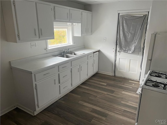 kitchen with dark wood-style flooring, a sink, light countertops, white cabinets, and white range with gas stovetop