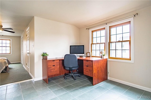 home office featuring baseboards, ceiling fan, and dark tile patterned floors