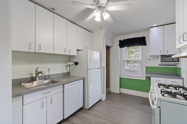kitchen featuring a ceiling fan, white appliances, baseboards, white cabinets, and a sink