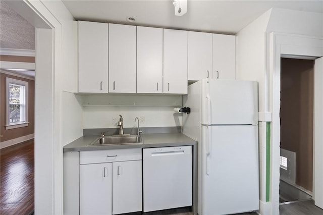 kitchen with a sink, dark wood finished floors, white cabinets, and white appliances