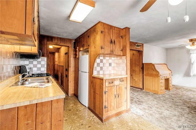 kitchen featuring freestanding refrigerator, light countertops, brown cabinets, tasteful backsplash, and a ceiling fan