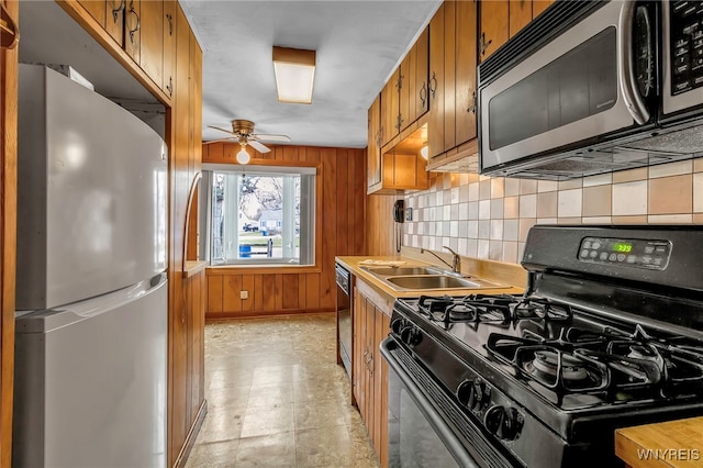 kitchen featuring brown cabinetry, a sink, appliances with stainless steel finishes, and tasteful backsplash