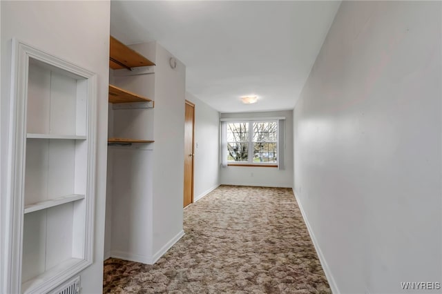 corridor featuring carpet floors and baseboards