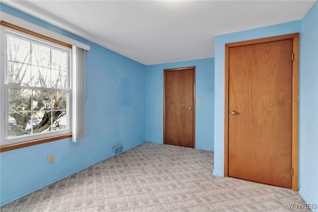 unfurnished bedroom featuring carpet floors, a closet, and visible vents