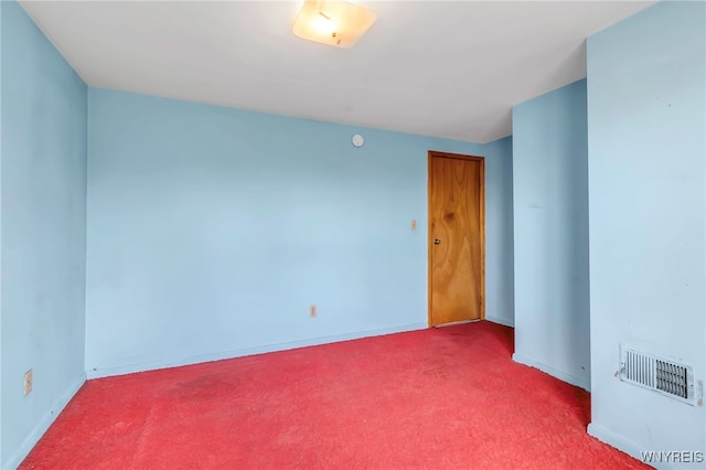 unfurnished room with baseboards, visible vents, and carpet