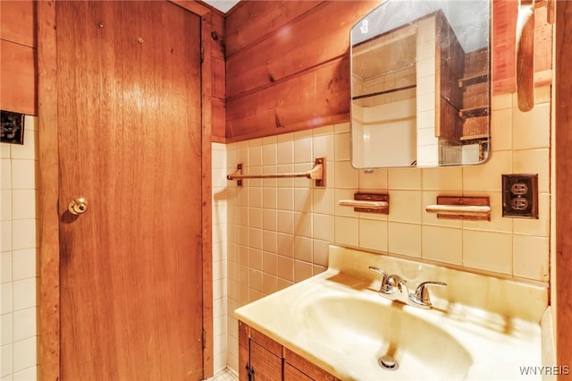 bathroom featuring vanity, tasteful backsplash, and tile walls