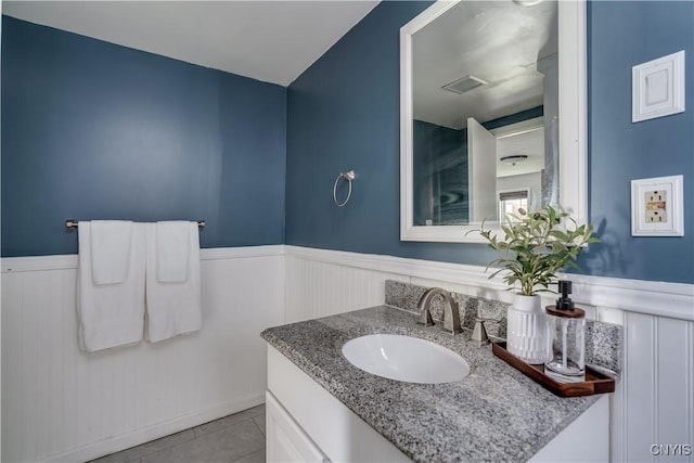 bathroom with tile patterned flooring, a wainscoted wall, visible vents, and vanity